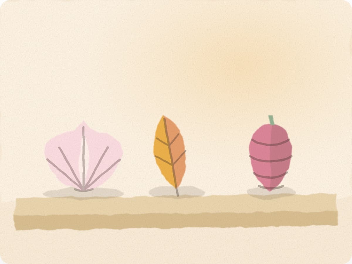 Trois feuilles d'automne alignées sur une étagère